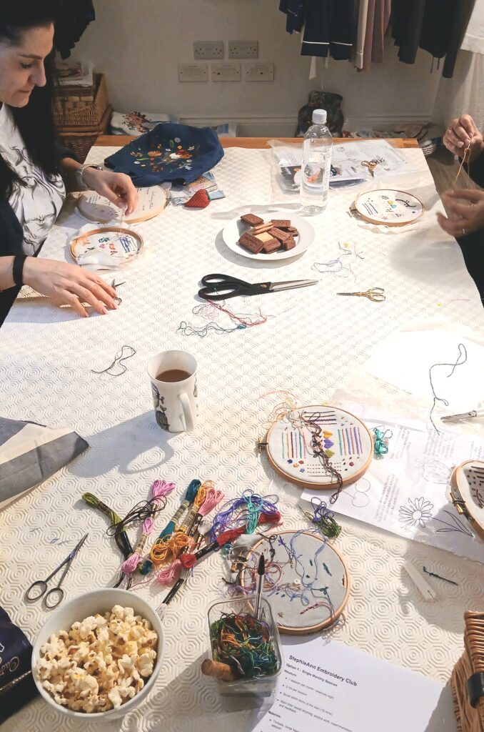 Embroidery threads, hoops, and fabric laid out for a stitching session Embroidery threads, hoops, and fabric laid out for a stitching session
